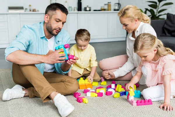 Iki Küçük Çocuklu Halı Üzerinde Oturan Renkli Bloklarla Oynama Aile — Stok fotoğraf