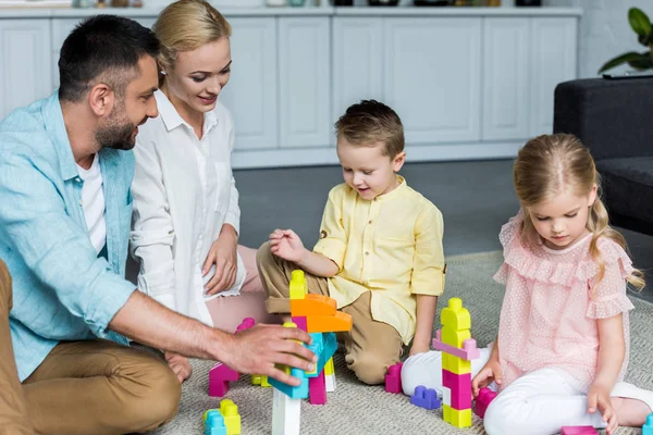 Pais Felizes Com Crianças Bonitos Brincando Com Blocos Coloridos Casa — Fotografia de Stock