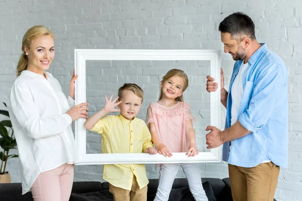 Happy Parents Holding Frame Cute Little Kids Smiling Camera — Stock Photo, Image