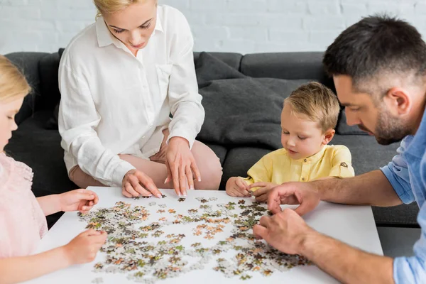 mutlu aile evde puzzle parçaları ile oynarken kırpılmış atış