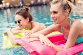 boldog, fiatal nők, felfújható matracok-medencében fekvő