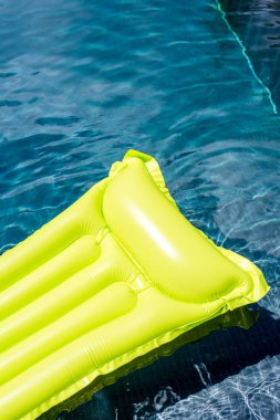 close-up shot of green inflatable mattress floating in swimming pool clipart