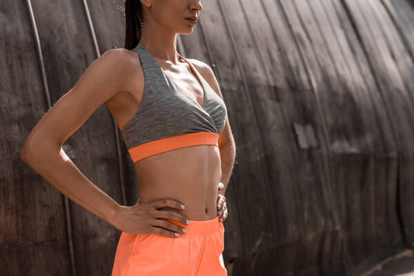 cropped view of athletic woman posing in sports bra