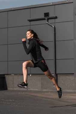 şehirde eğitim genç gülümseyen atletik jogging yapan