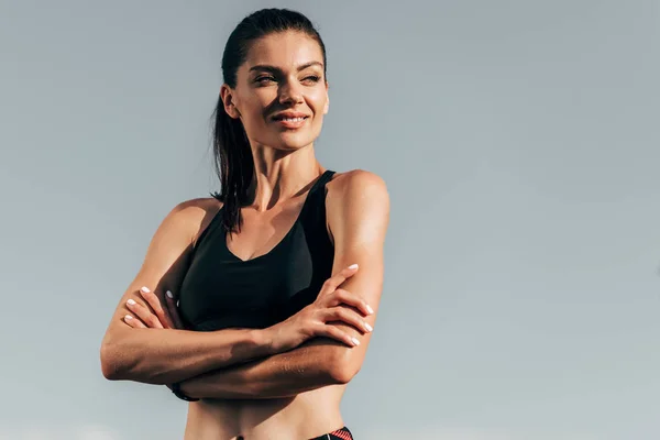 Hermosa Deportista Sonriente Con Brazos Cruzados Posando Contra Cielo Azul —  Fotos de Stock