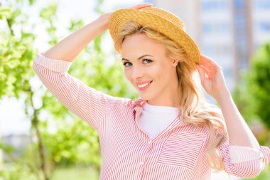 portrait of smiling young woman in straw hat on blurred background  clipart