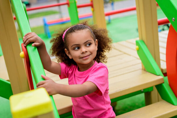 curly african american little child looking away playground 