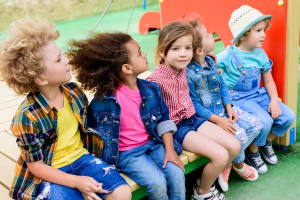 Щасливі Багатоетнічні Маленькі Діти Сидять Разом Дитячому Майданчику — стокове фото
