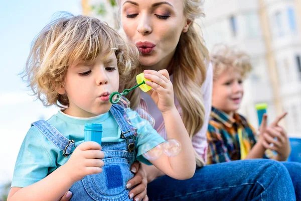 Foco Seletivo Mãe Filho Pequeno Usando Ventilador Bolhas Enquanto Outro — Fotografia de Stock