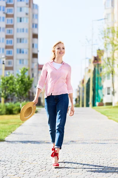 Mulher Elegante Feliz Segurando Chapéu Palha Andando Rua — Fotografia de Stock