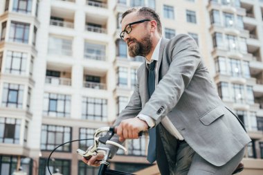 yakışıklı işadamı şehir bisiklet sürme takım elbiseli sakallı 