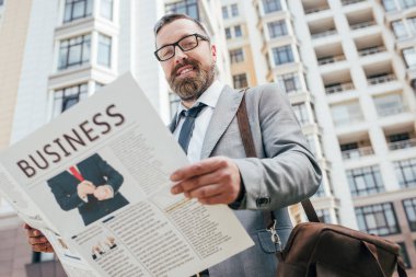 Şehirde iş gazete tutan yakışıklı sakallı işadamı