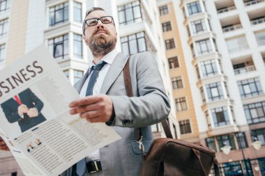 yakışıklı sakallı işadamı ile iş gazete ve deri çanta şehir