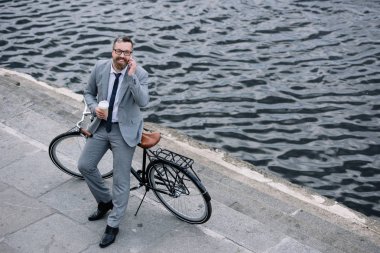 işadamı kahve ile smartphone üzerinde konuşmak ve İskele kiralama ile ayakta