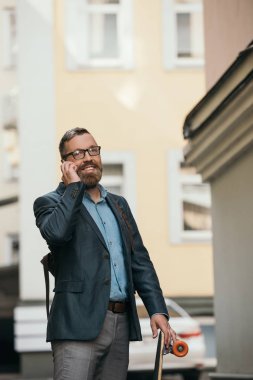 smartphone City'deki konuşurken longboard ile şık adam sakallı