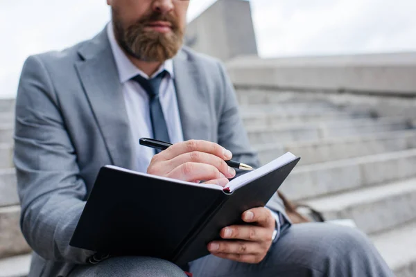 Ausgeschnittene Ansicht Eines Geschäftsmannes Der Tagebuch Schreibt Und Auf Einer — Stockfoto