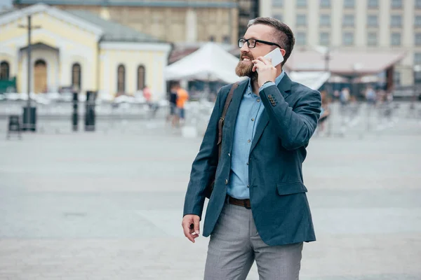 胡子时尚商人谈论智能手机在城市 — 图库照片