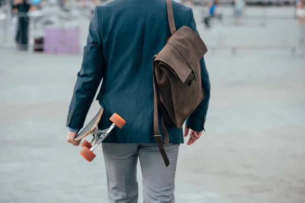 Beskurna Bakifrån Man Med Läder Ryggsäck Och Skateboard Promenader City — Stockfoto