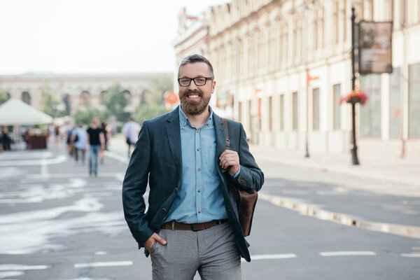 happy stylish man in jacket walking in city