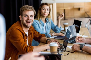 Office başlangıç proje üzerinde ve uzağa bakarak çok kültürlü meslektaşları gülümseyen
