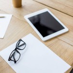 Tablet und Brille auf Holztisch im Büro