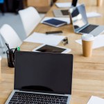 Ноутбук з порожнім екраном на дерев'яному столі в діловому офісі