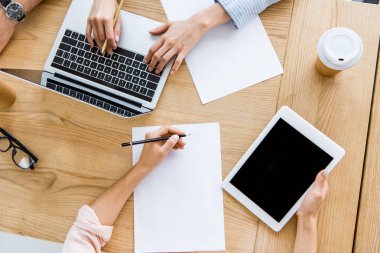 başlangıç proje içinde yazıhane ile tablet ve dizüstü bilgisayar üzerinde meslektaşlarının resim kırpılmış
