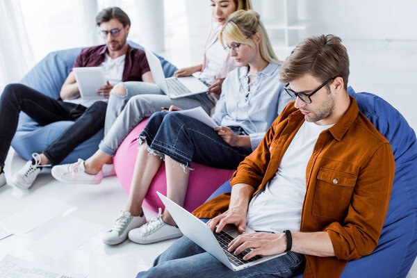 multicultural colleagues working on startup project with laptops in office