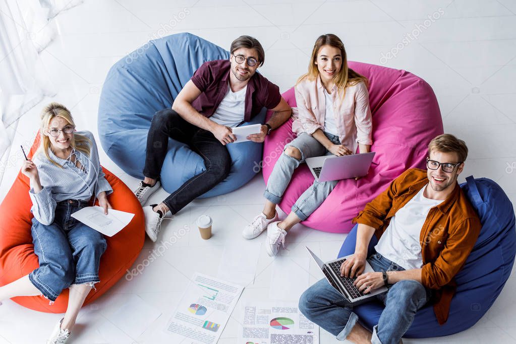 high angle view of multicultural colleagues working on startup project in office with gadgets