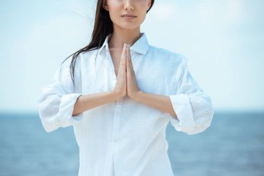 Asyalı kadın namaste mudra jesti önünde deniz yapıyor kısmi görünümünü 