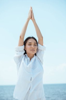  Asyalı kadın kapalı gözlerle asana vrikshasana (ağaç poz) deniz yoluyla ayakta konsantre