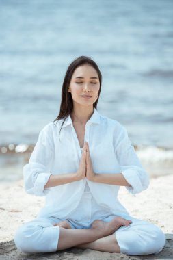 anjali mudra (selamlama mühür) poz sahilde Genç Asyalı kadın 