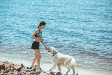 Asyalı kadın labrador deniz ile oynarken uzak görünümünü