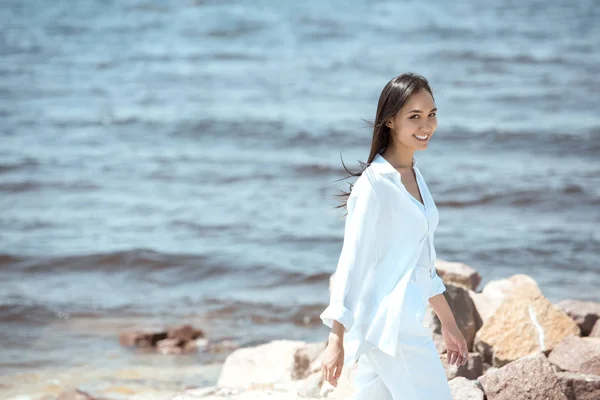 Feliz Joven Asiático Mujer Mirando Cámara Mientras Pie Playa Por — Foto de stock gratis