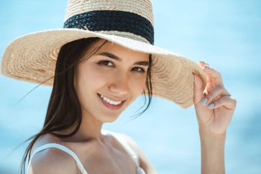 close up portrait of attractive asian woman in straw hat looking at camera clipart