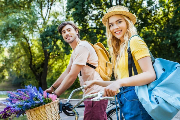 Widok Boku Uśmiechnięta Para Rowerami Patrząc Kamery Lato Park — Zdjęcie stockowe