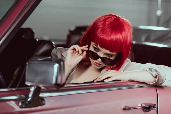 Beautiful Stylish Girl Red Wig Adjusting Sunglasses Looking Car Mirror — Free Stock Photo