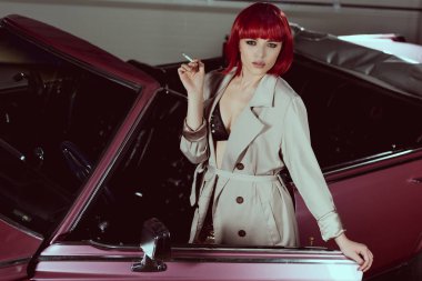 Sigara ve kamera retro car yakınındaki dururken bakarak şık kız yüksek açılı görünüş