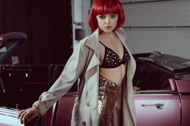 güzel genç kadın moda trençkot retro car yakınındaki dururken kamera bakıyor  