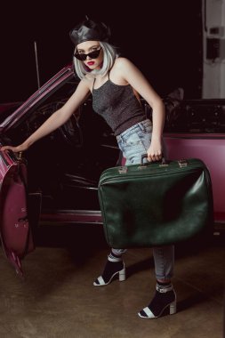 bere ve eski model araba ve holding eski moda çanta açma güneş gözlükleri şık sarışın kadın
