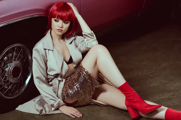 高角度的时尚女孩在红色假发看着坐在老式汽车 — 图库照片