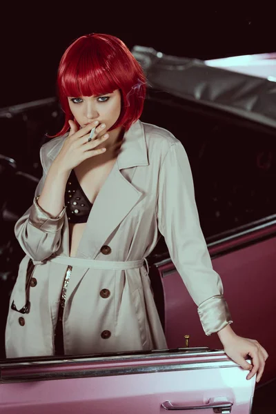 Hermosa Mujer Peluca Roja Gabardina Fumar Cigarrillo Mirando Cámara Cerca — Foto de stock gratis
