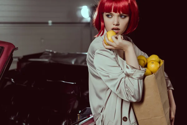 Stylish Girl Trench Coat Holding Paper Bag Lemons Looking Away — Stock Photo, Image