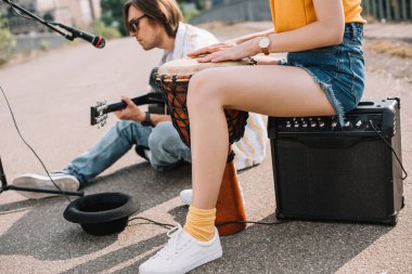 Djembe ve güneşli şehir sokak üzerinde performans gitar adamla kadın ile
