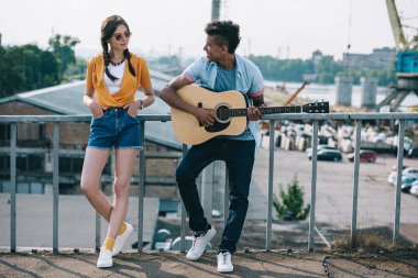 Afrika kökenli Amerikalı adama sokakta performans gitar dinlerken kız