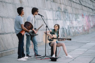 Takım genç arkadaşlar gitar ve djembe kentsel ortamda oynuyor