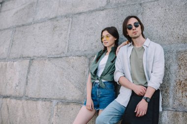 Kentsel ortamda beklemede gitar ile genç arkadaş çift duvar