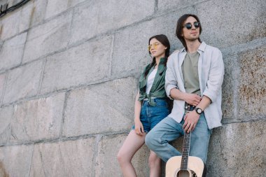 Genç kız ve adam wall Street tarafından gitar tutarak güneş gözlüğü