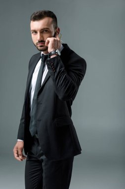 Yakışıklı güvenlik görevlisi dinleme ileti güvenlik kulaklık ve uzak gri izole arıyorsunuz