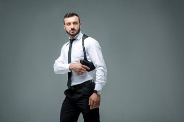 yakışıklı güvenlik görevlisi alarak silah ve uzak gri izole arıyorsunuz